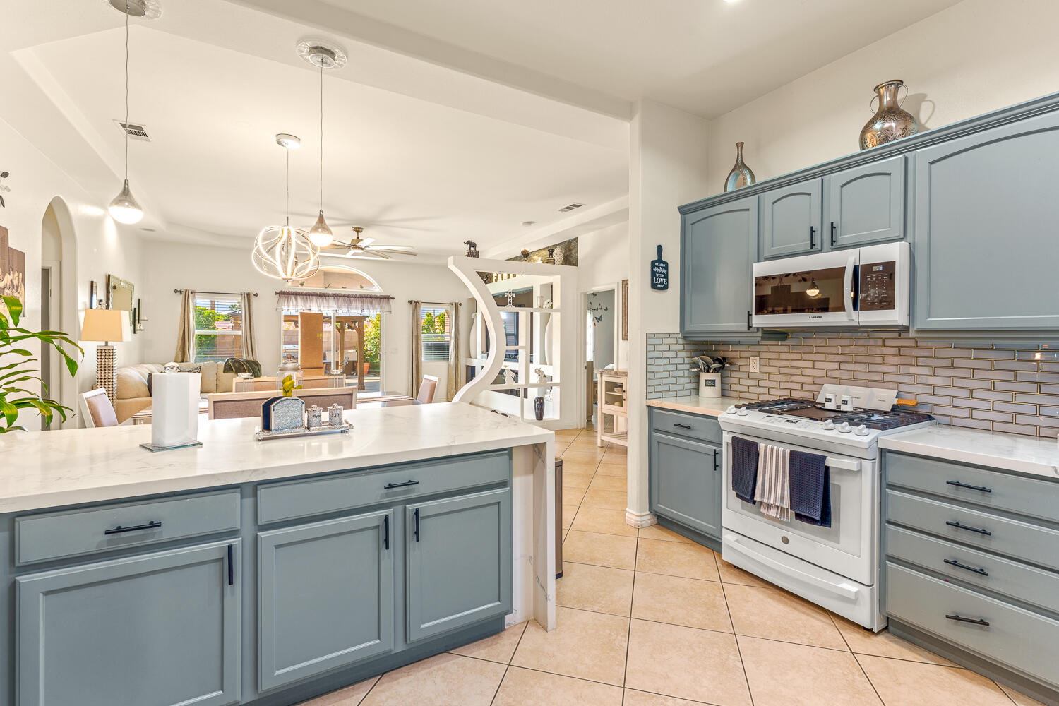 67305 Medano Road Cathedral City, CA 92234 - Photo 4 of 37 a kitchen with stainless steel appliances granite countertop a stove a sink and a microwave