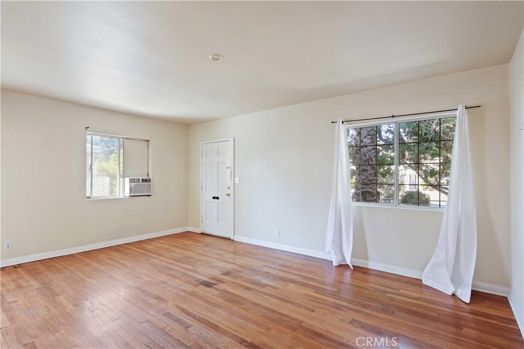 5940 Cedros Avenue Van Nuys, CA 91411 - Photo 5 of 23 a view of an empty room with wooden floor and a window