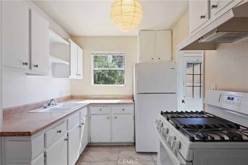 5940 Cedros Avenue Van Nuys, CA 91411 - Photo 10 of 23 a kitchen with granite countertop a sink stove and cabinets
