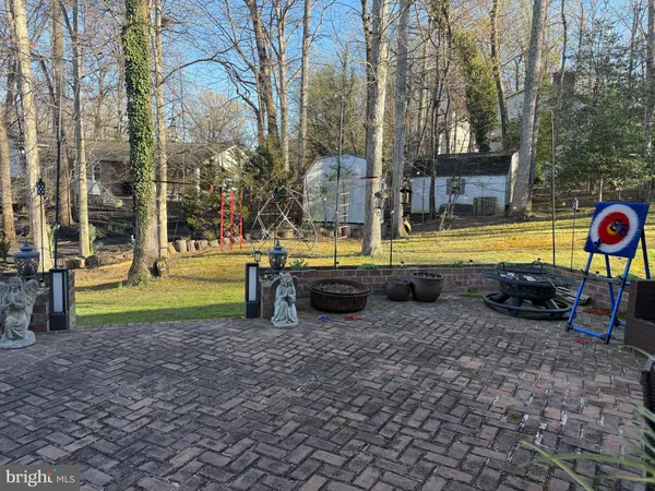 a view of a swimming pool with lawn chairs and large trees