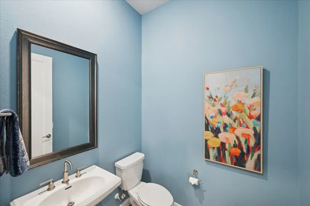 a bathroom with a toilet sink and mirror