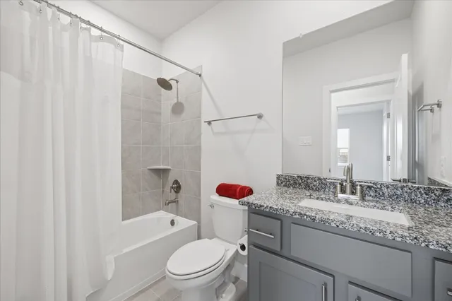 a bathroom with a granite countertop toilet sink and a bathtub