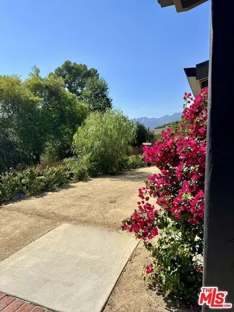a street view with flower plants and wooden fence