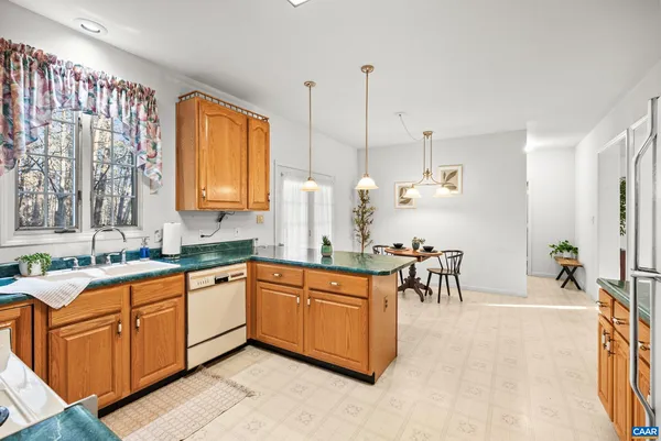 a kitchen with granite countertop a stove a sink and a refrigerator