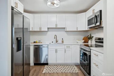 a kitchen with stainless steel appliances a refrigerator sink and cabinets