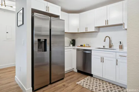 a kitchen with white cabinets and stainless steel appliances