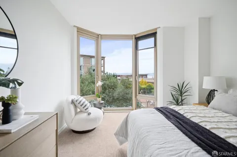 a bedroom with a bed a mirror and a potted plant