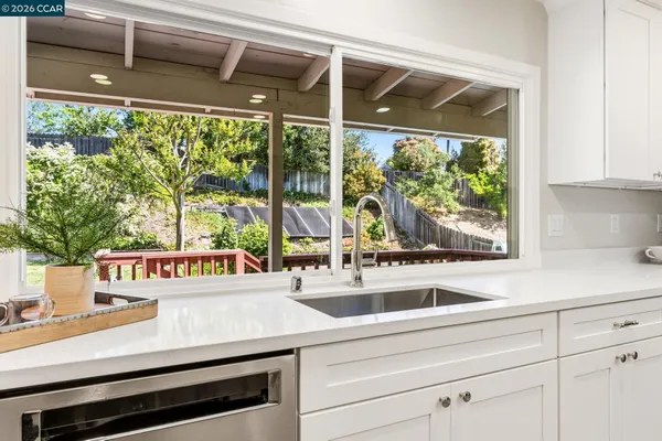 a kitchen with white cabinets and a window