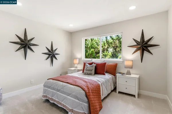 a bedroom with two beds and a potted plant