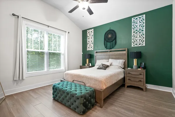 a bedroom with a bed dresser and a window