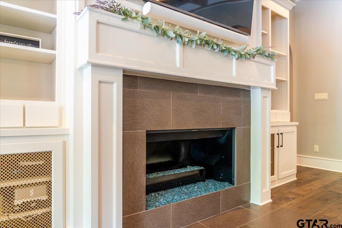6527 Rochester Way Tyler, TX 75703 - Photo 6 of 48 a hallway with a fireplace and a wooden floor