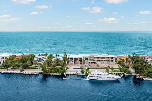 an aerial view of a house with outdoor space and lake view in back