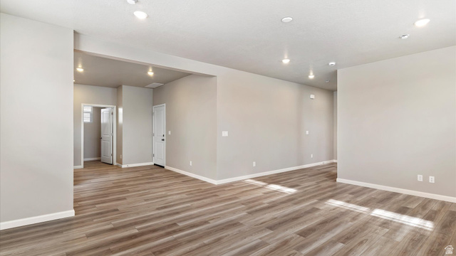 82 Provo River Road, Unit 251 Saratoga Springs, UT 84045 - Photo 4 of 32 Spacious room featuring wood-finish flooring, recessed lighting, neutral paint, white baseboards, and white doors