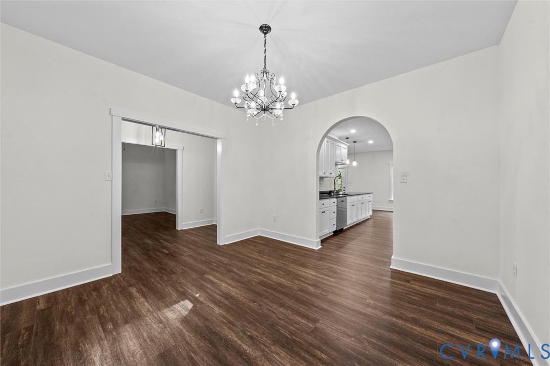 4062 Lake Killarney Road Gum Spring, VA 23065 - Photo 14 of 37 an empty room with wooden floor chandelier and windows