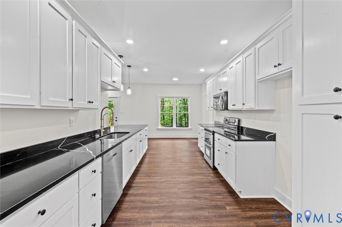 4062 Lake Killarney Road Gum Spring, VA 23065 - Photo 19 of 37 a large kitchen with stainless steel appliances granite countertop a stove a sink and white cabinets