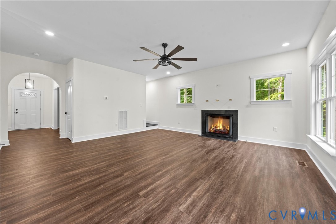 4062 Lake Killarney Road Gum Spring, VA 23065 - Photo 28 of 37 an empty room with wooden floor a fireplace and windows