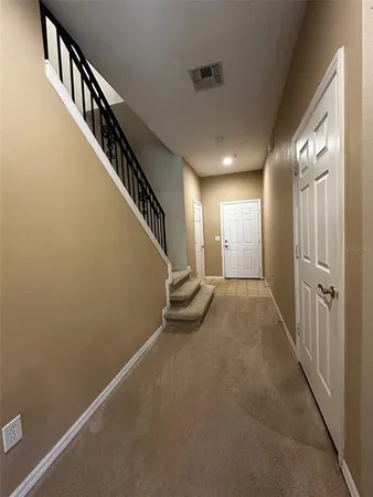 a view of staircase with railing and white walls