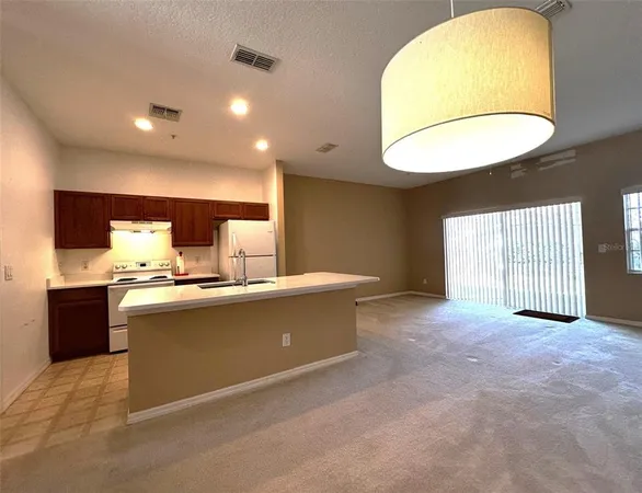 a kitchen with a sink a refrigerator and window