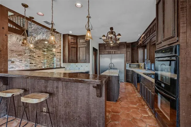 a kitchen with granite countertop a stove a sink and a refrigerator