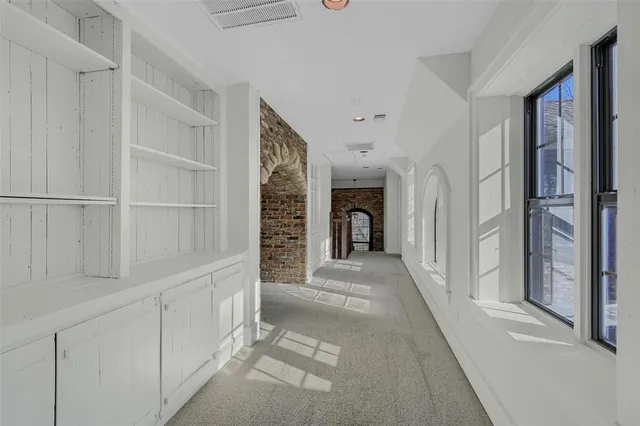 a hallway with white cabinets and entryway
