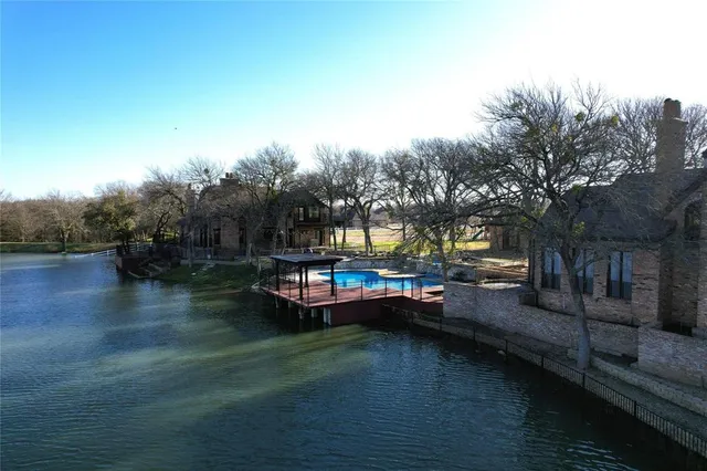 a view of swimming pool with chairs and wooden fence