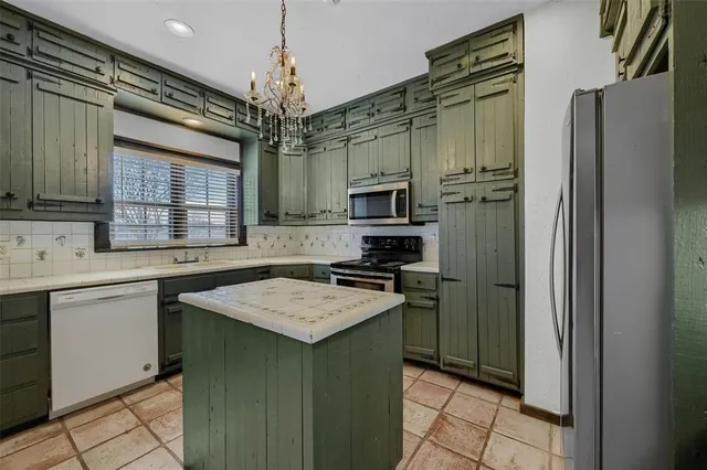 a kitchen that has a refrigerator a stove and a sink