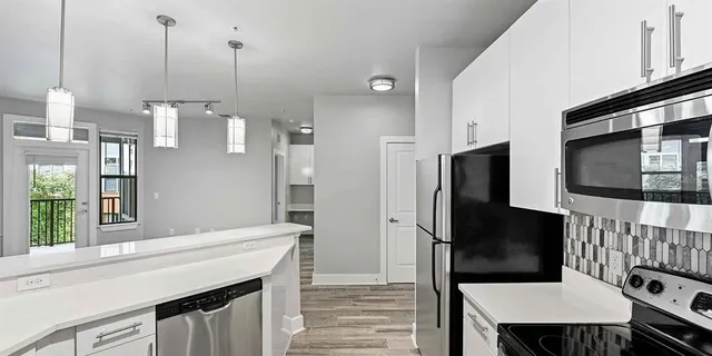 a kitchen with stainless steel appliances kitchen island a refrigerator sink and stove