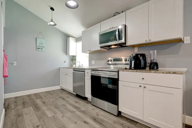 a kitchen with a sink cabinets and wooden floor
