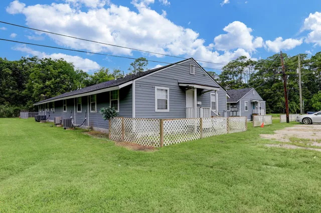 a front view of a house with a garden and trees