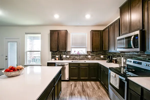 a kitchen with stainless steel appliances a sink stove and refrigerator