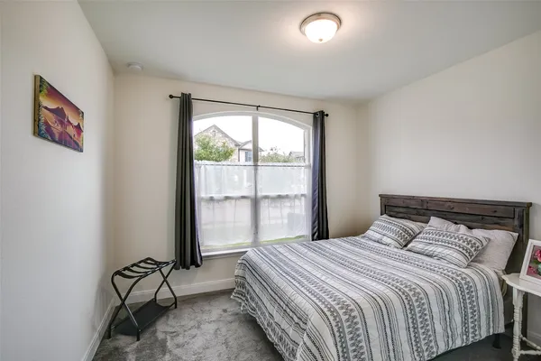 a bedroom with a bed and glass door