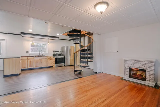 a view of a livingroom with wooden floor and a fireplace