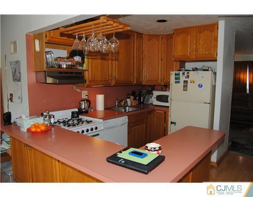 130 Idlewild Road Edison, NJ 08817 - Photo 3 of 12 a kitchen with a refrigerator and a stove top oven