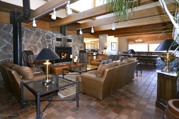 a living room with fireplace furniture and a large window