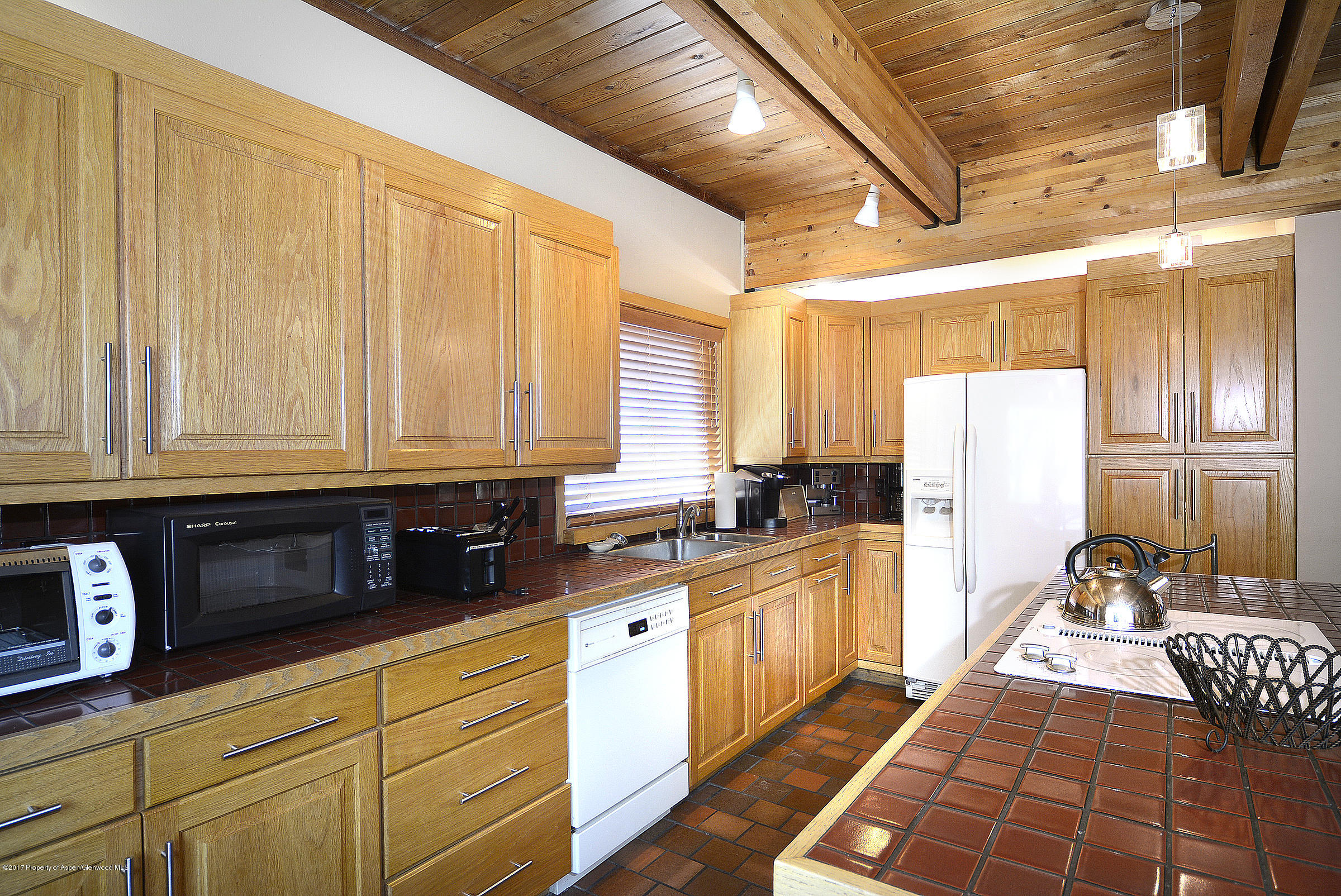 2076 Faraway Road Snowmass Village, CO 81615 - Photo 9 of 21 a kitchen with granite countertop a sink a window stainless steel appliances and cabinets