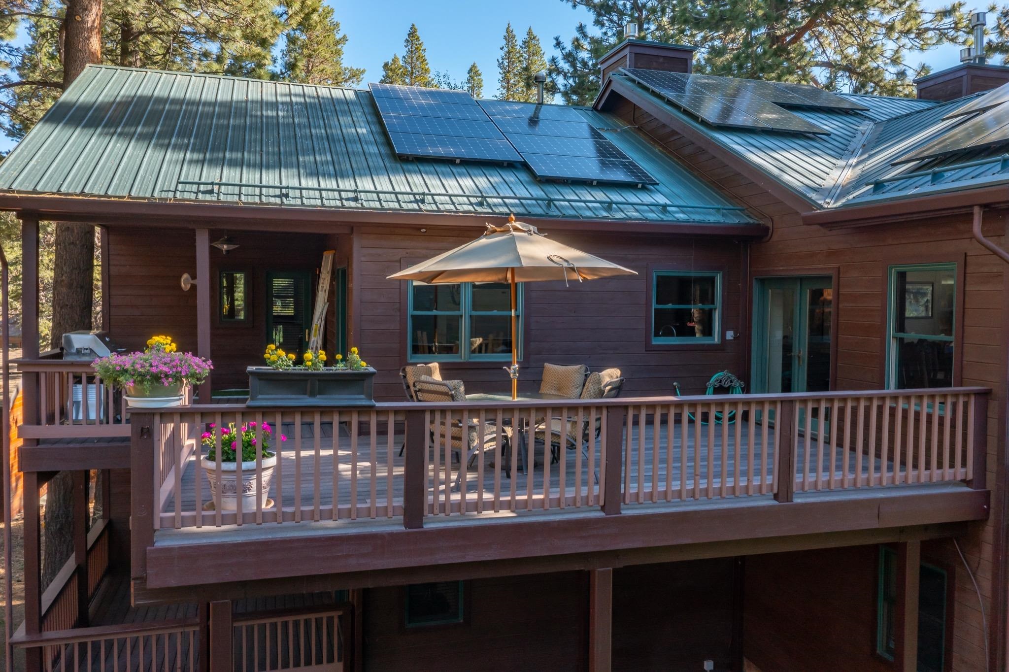 378 Ridge Way Mammoth Lakes, CA 93546 - Photo 39 of 43 Multi-level wood deck featuring a railing system and integrated solar panels on the metal roof