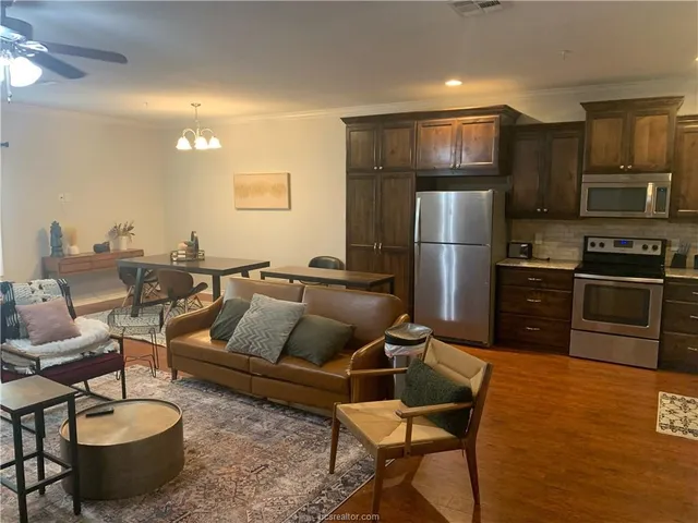 a living room with furniture a rug and kitchen view