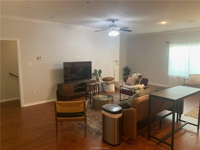 a living room with furniture a flat screen tv and kitchen view