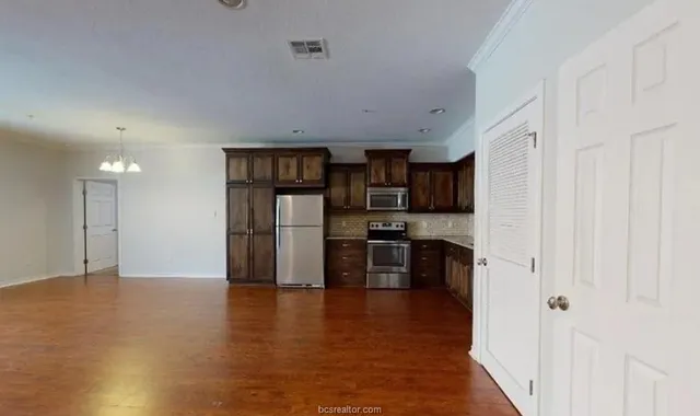 a kitchen with stainless steel appliances a refrigerator and a stove top oven