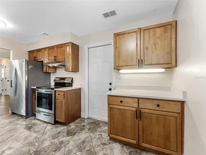 a kitchen with cabinets microwave and refrigerator