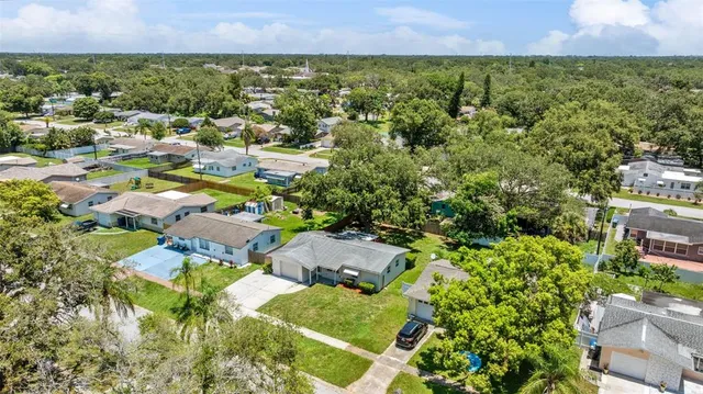 an aerial view of residential house with outdoor space and trees all around