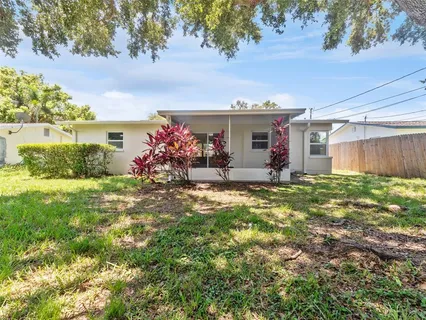 a front view of house with yard and trees in the background