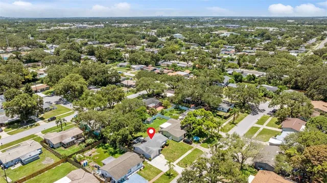 an aerial view of residential houses with outdoor space and trees