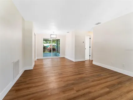 a view of an empty room with window and wooden floor