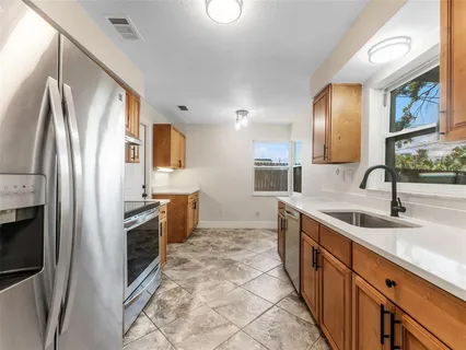 a kitchen with stainless steel appliances granite countertop a sink stove and refrigerator