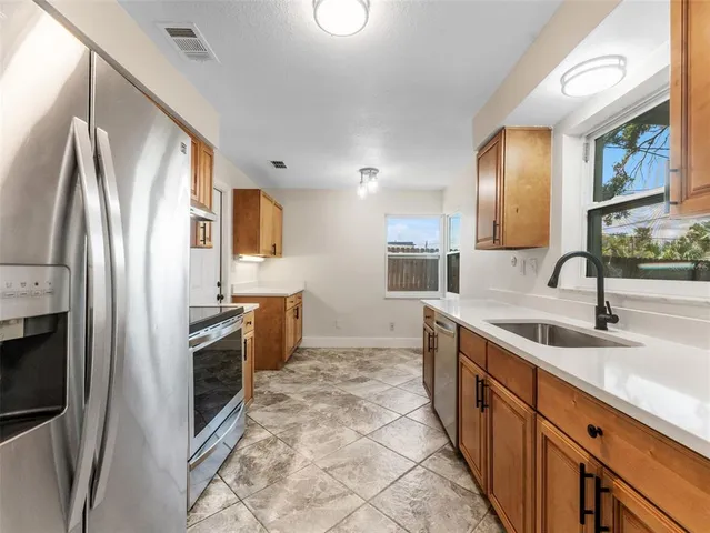 a kitchen with stainless steel appliances granite countertop a sink stove and refrigerator