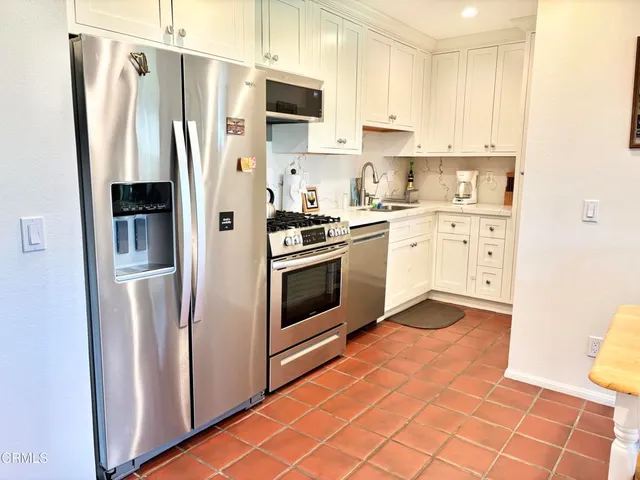 a kitchen with stainless steel appliances a refrigerator sink and microwave