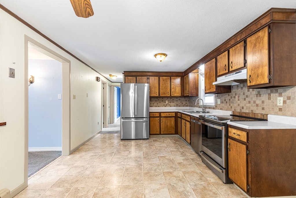 99 Swansom Road Swansea, MA 02777 - Photo 9 of 42 a large kitchen with stainless steel appliances granite countertop a refrigerator and a stove top oven