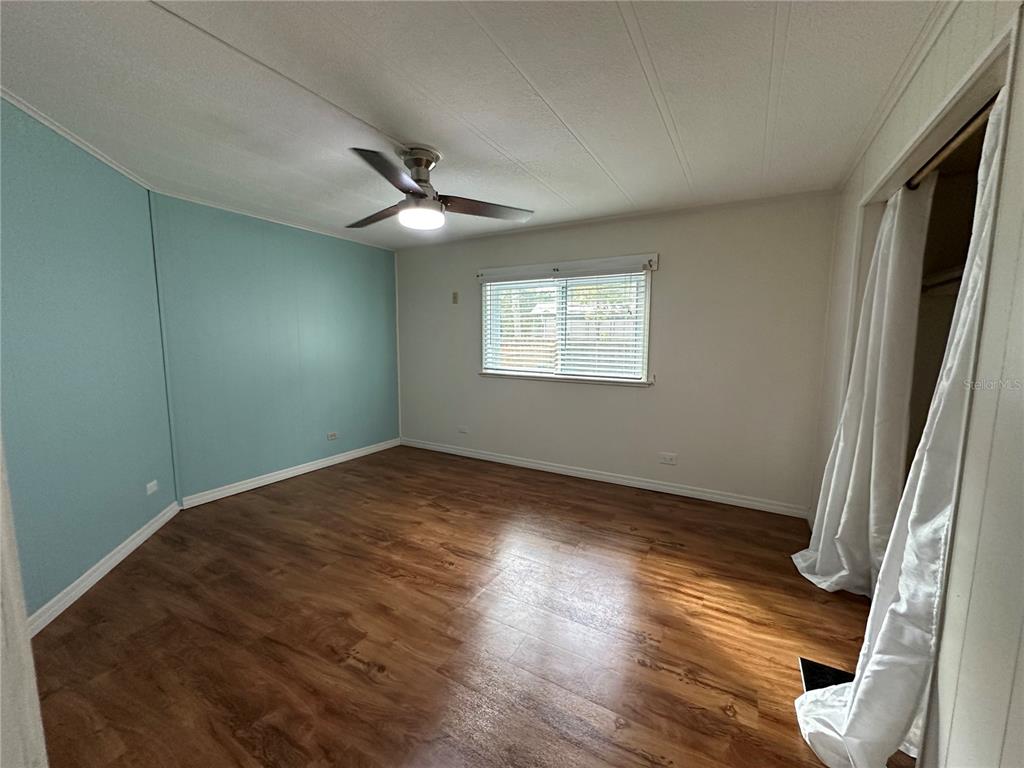 24007 River Road Astor, FL 32102 - Photo 15 of 37 an empty room with wooden floor and windows