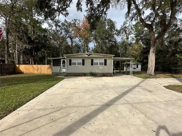 a view of a house with backyard and a tree
